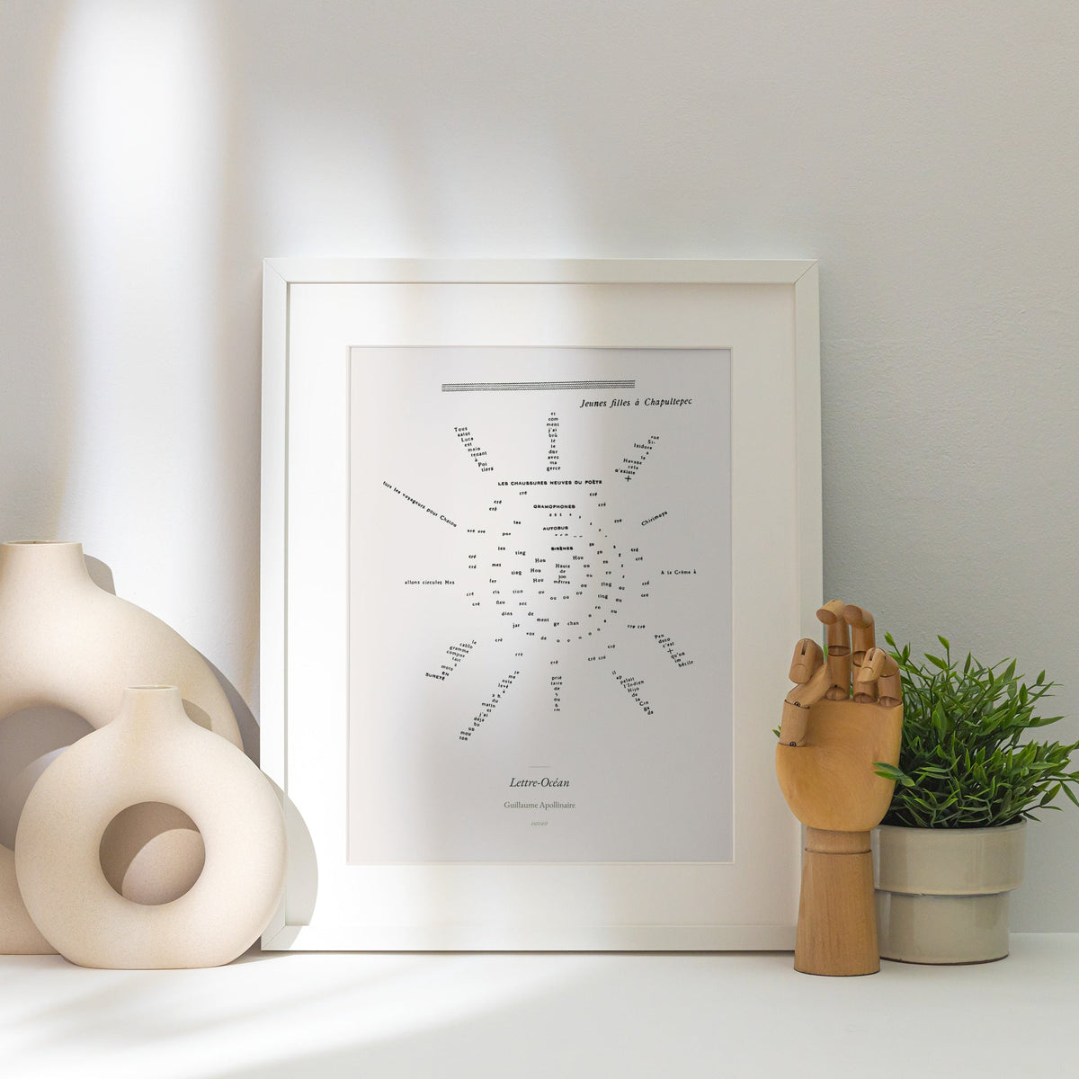 Lettre-Océan - Apollinaire - Affiche Calligramme Soleil, affiche encadrée posée près d'un vase blanc, lumière rasante