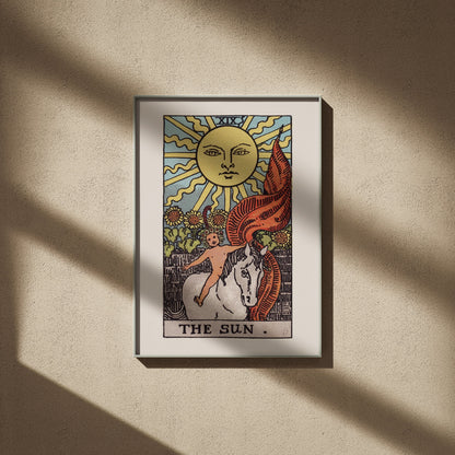 Le Soleil, arcane XIX du tarot Rider-Waite en 50x70, encadré sur un mur beige, ombres de fenêtre