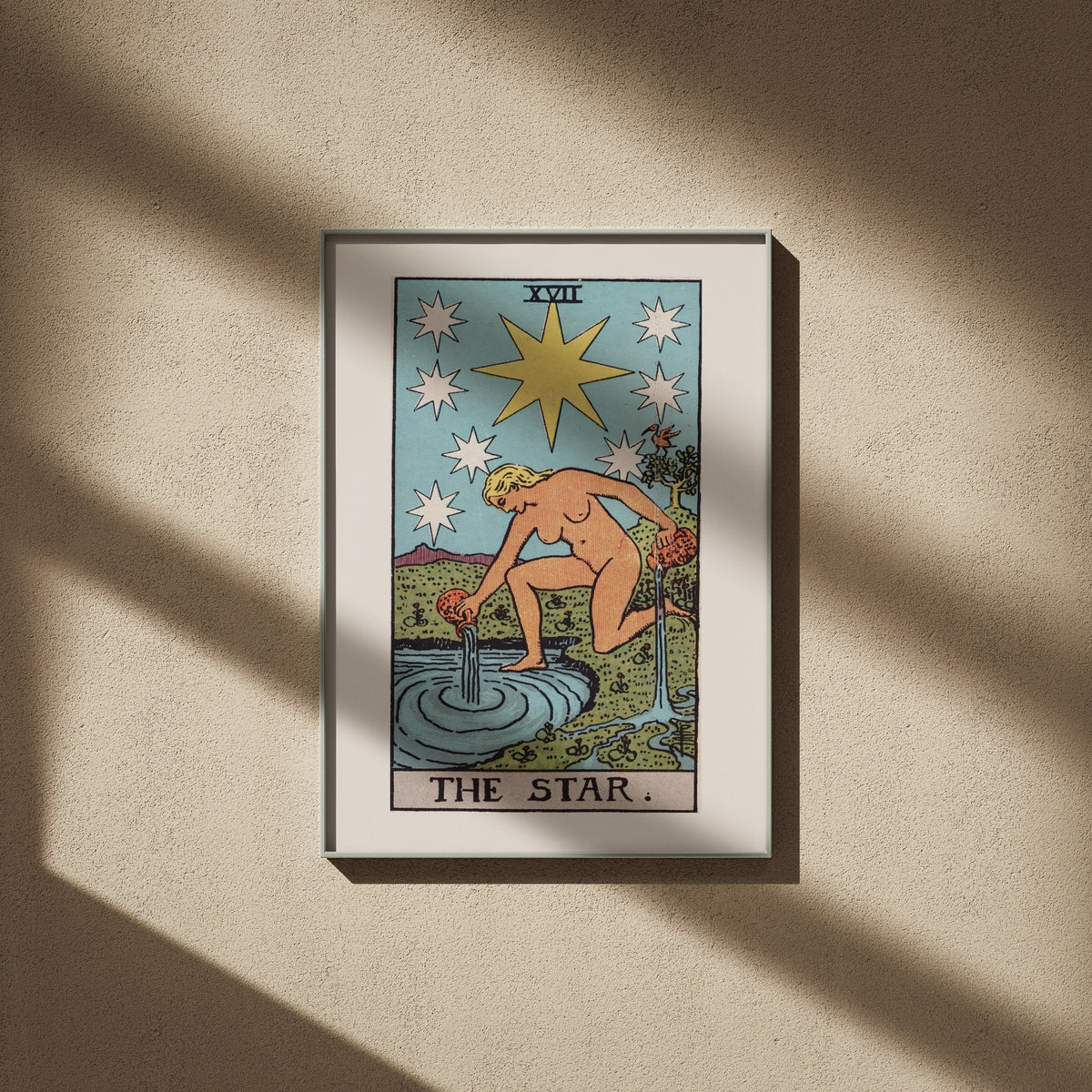 L'Étoile, arcane XVII du tarot Rider-Waite en 50x70, encadré sur un mur beige, ombres de fenêtre