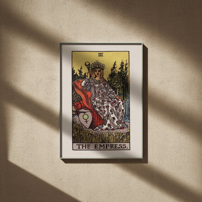 L'Impératrice, arcane III du tarot Rider-Waite en 50x70, encadré sur un mur beige, ombres de fenêtre