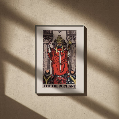 Le Hiérophante, arcane V du tarot Rider-Waite en 50x70, encadré sur un mur beige, ombres de fenêtre