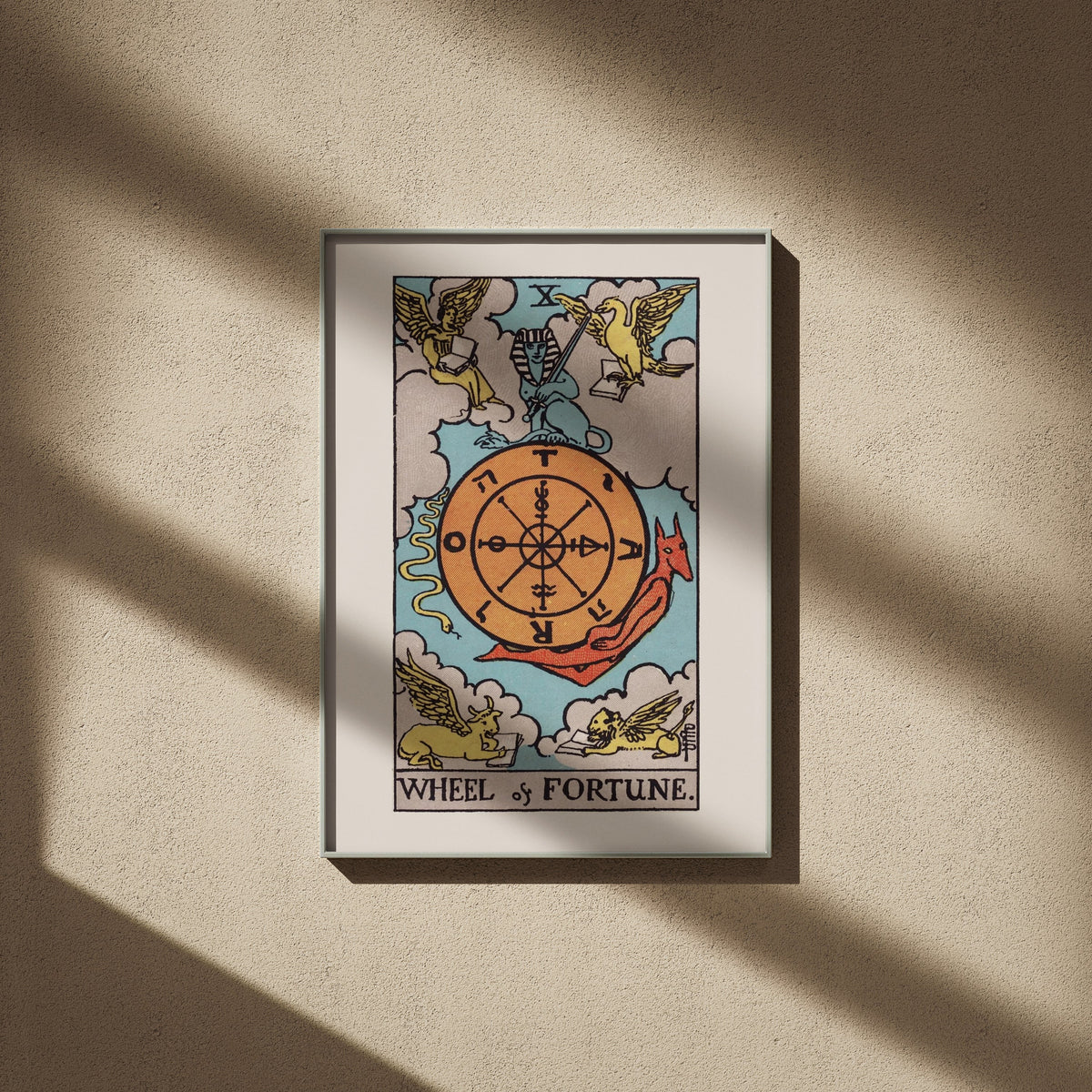 Wheel of Fortune, X: Rider-Waite tarot print, 20x28, framed on a beige wall with window shadows