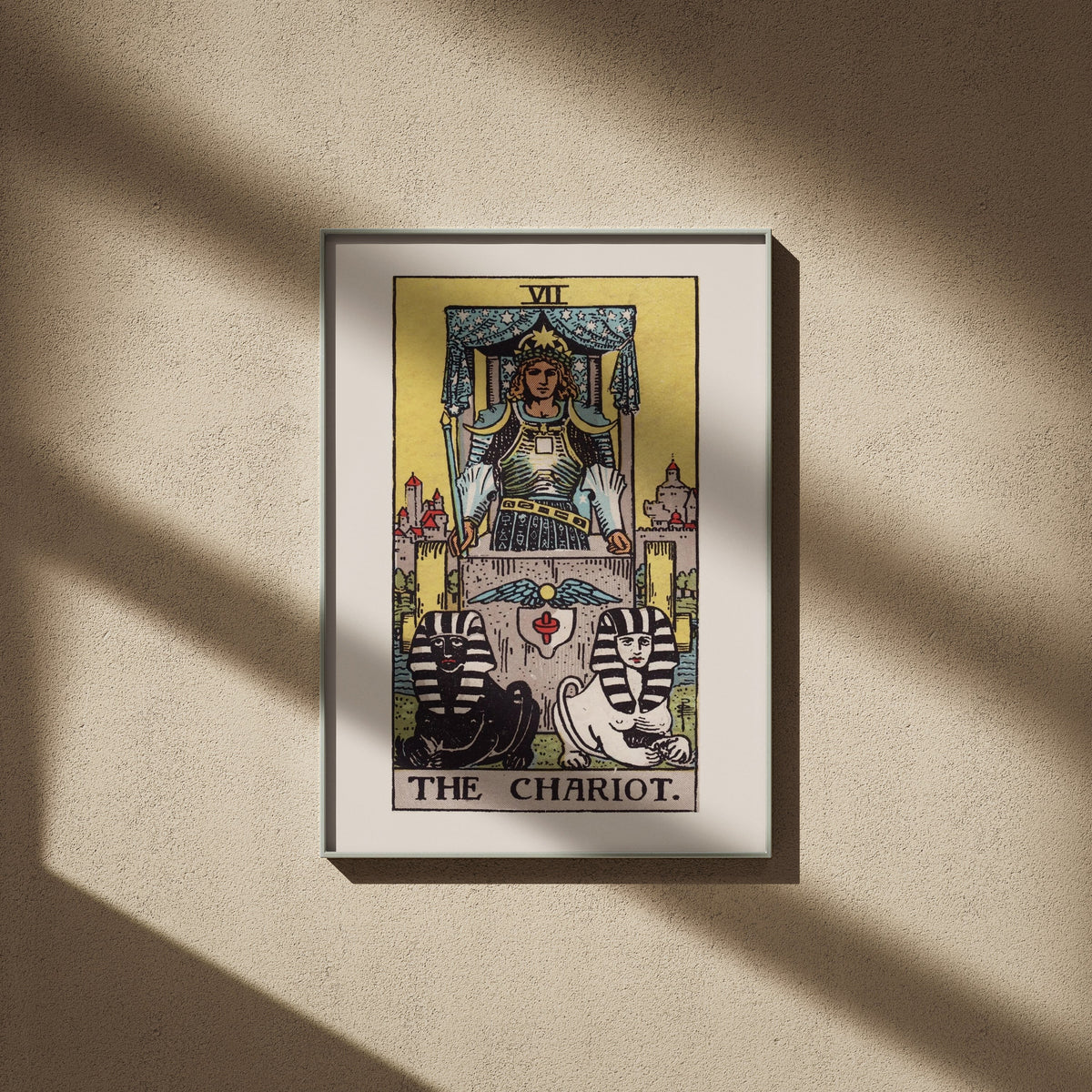 Le Chariot, arcane VII du tarot Rider-Waite en 50x70, encadré sur un mur beige, ombres de fenêtre