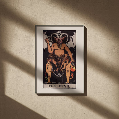 Le Diable, arcane XV du tarot Rider-Waite en 50x70, encadré sur un mur beige, ombres de fenêtre