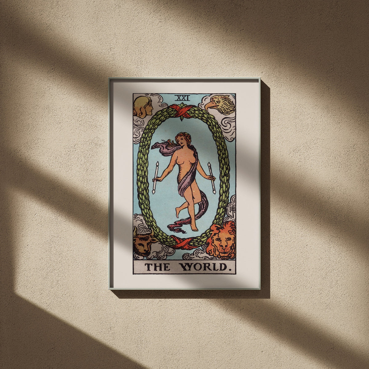 Le Monde, arcane XXI du tarot Rider-Waite en 50x70, encadré sur un mur beige, ombres de fenêtre