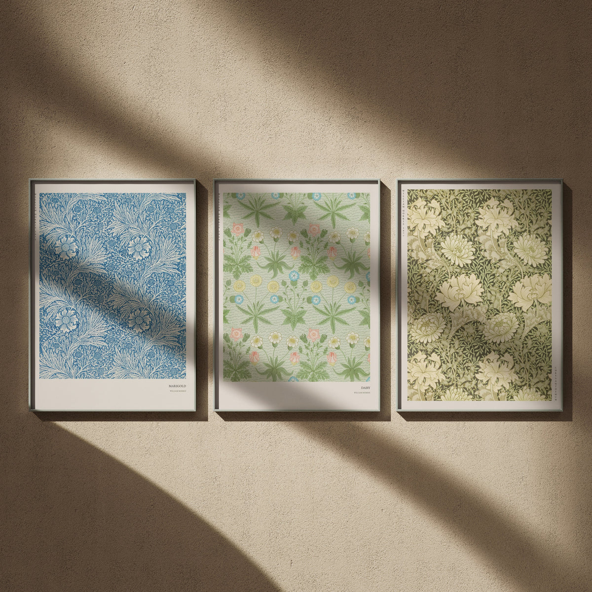 Triptyque William Morris en 50x70 : Marigold, Daisy et Chrysanthemum, encadrés côte à côte sur un mur beige