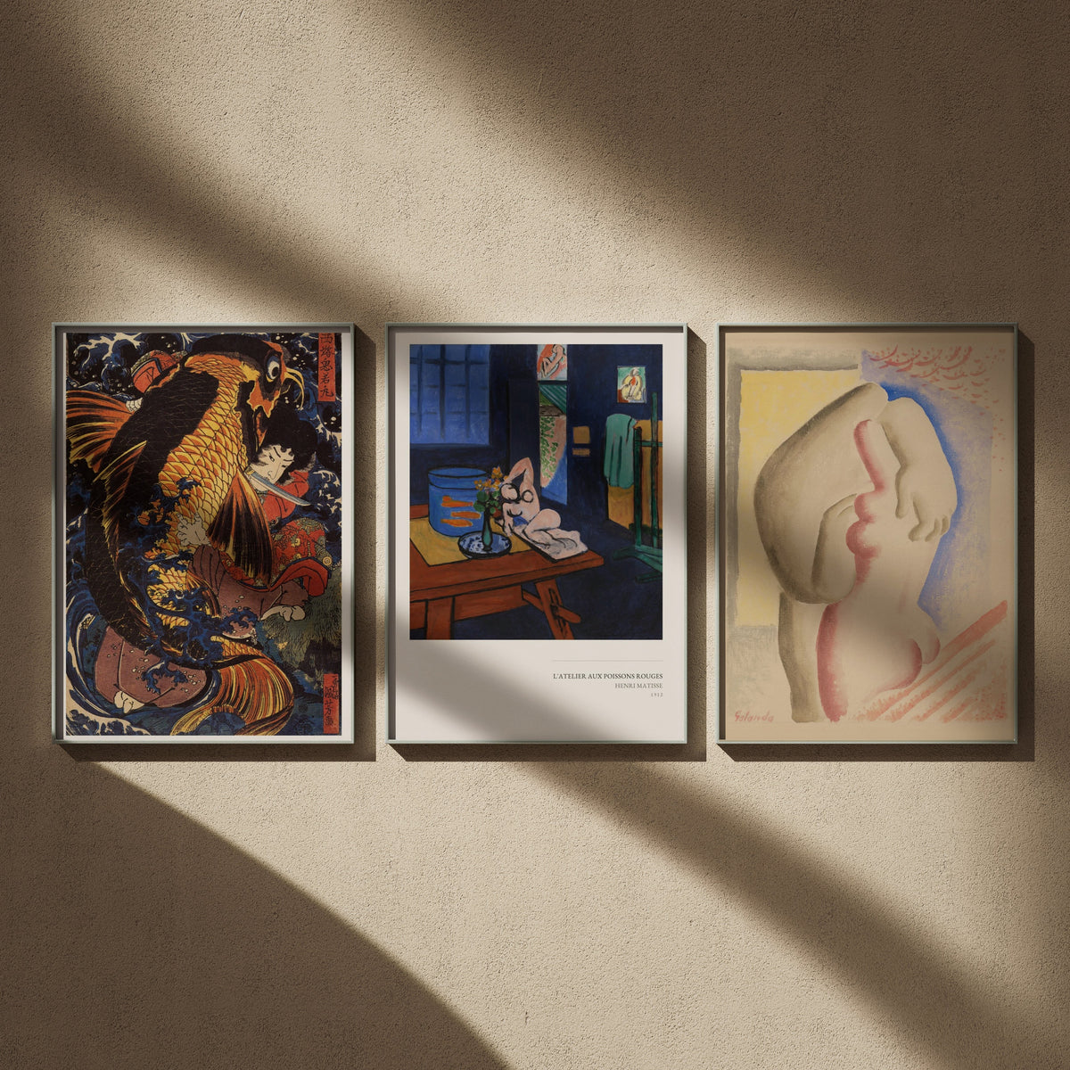 Triptyque musée en 50x70 : Oniwakamaru et la carpe géante, L'Atelier aux poissons rouges et Les Amoureux, encadrés côte à côte sur un mur beige