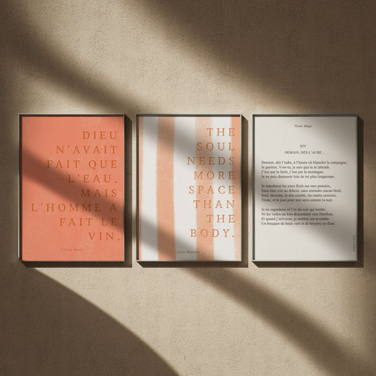 Triptyque citations littéraires en 50x70 : Mais l'homme a fait le vin, The soul needs more space, Axel Munthe et Demain, dès l'aube, encadrés côte à côte sur un mur beige