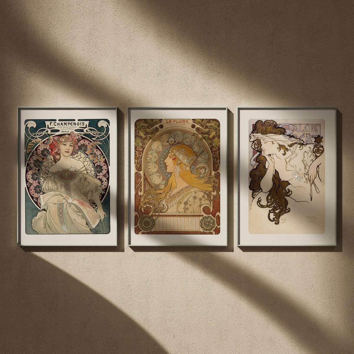 Triptyque Alphonse Mucha en 50x70 : Rêverie, Zodiaque et Salon des Cent, encadrés côte à côte dans un intérieur clair