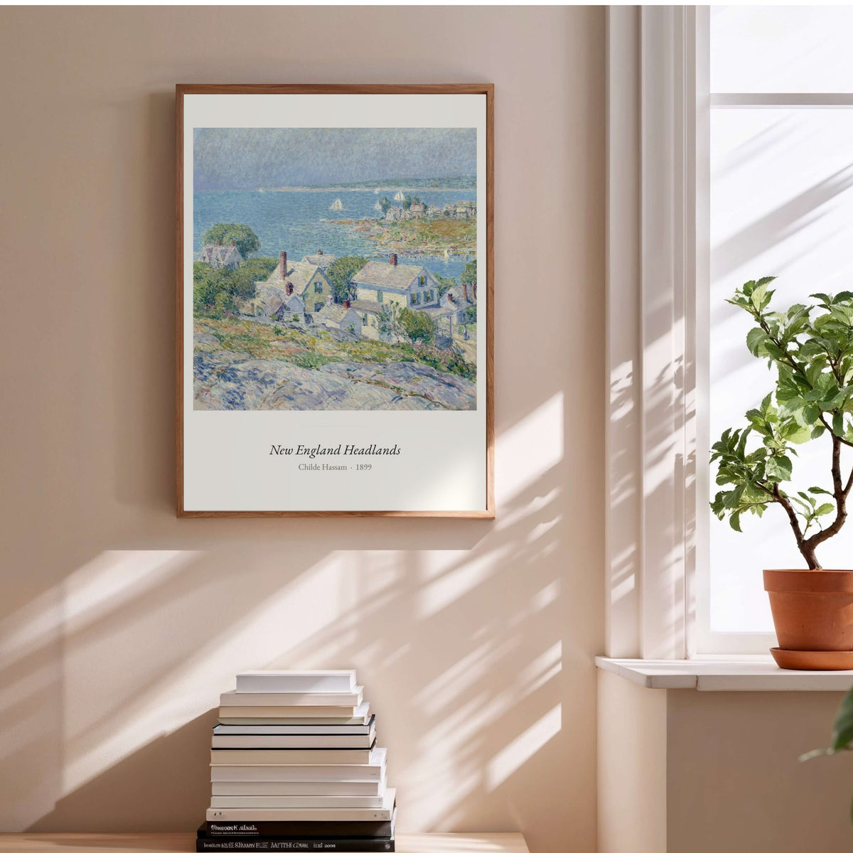 New England Headlands, Childe Hassam, affiche encadrée au-dessus d'une pile de livres