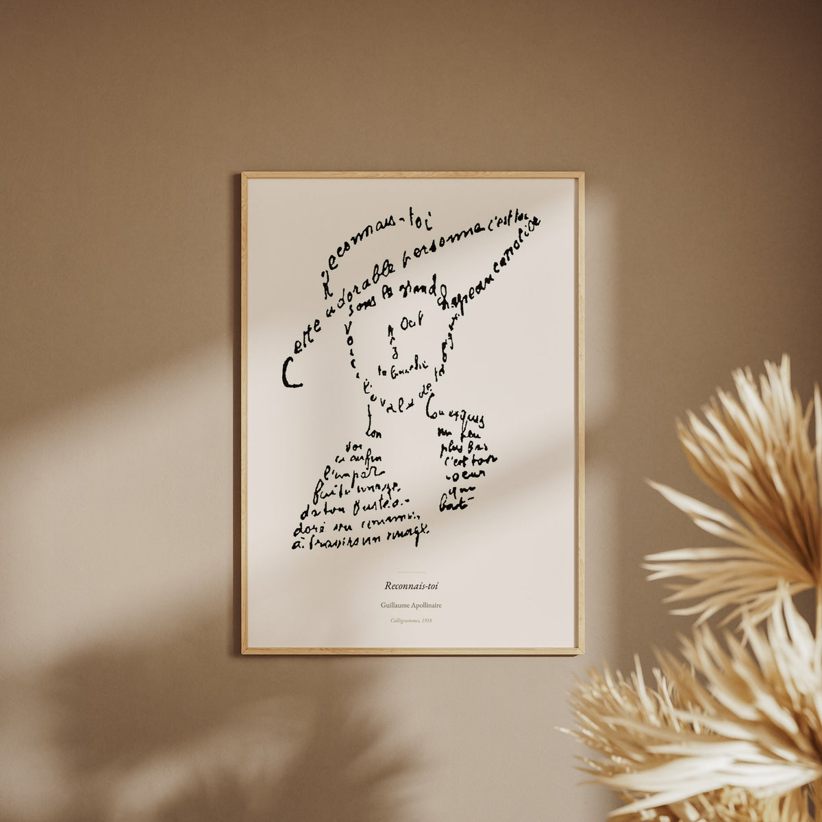 Reconnais-toi - Apollinaire - Affiche Calligramme Poésie, affiche encadrée sur un mur beige, pampas au premier plan