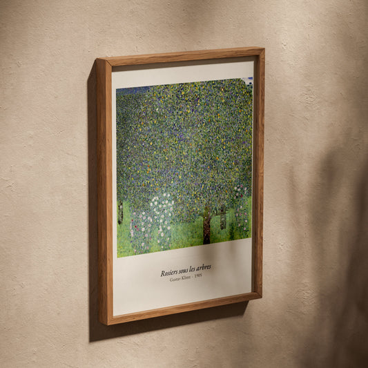 Rosiers sous les arbres, Gustav Klimt, affiche dans un cadre en chêne posé de biais sur un mur texturé