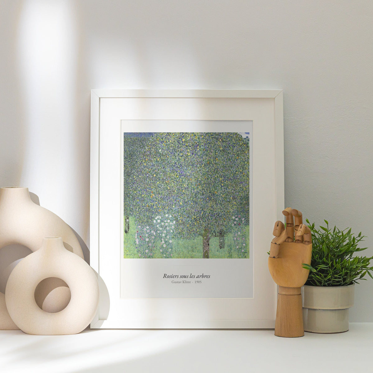 Rosiers sous les arbres, Gustav Klimt, affiche encadrée posée près d'un vase blanc, lumière rasante