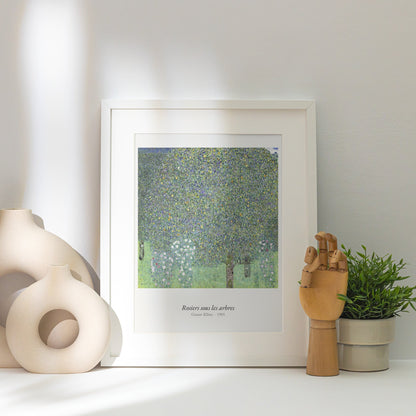 Rosiers sous les arbres, Gustav Klimt, affiche encadrée posée près d'un vase blanc, lumière rasante