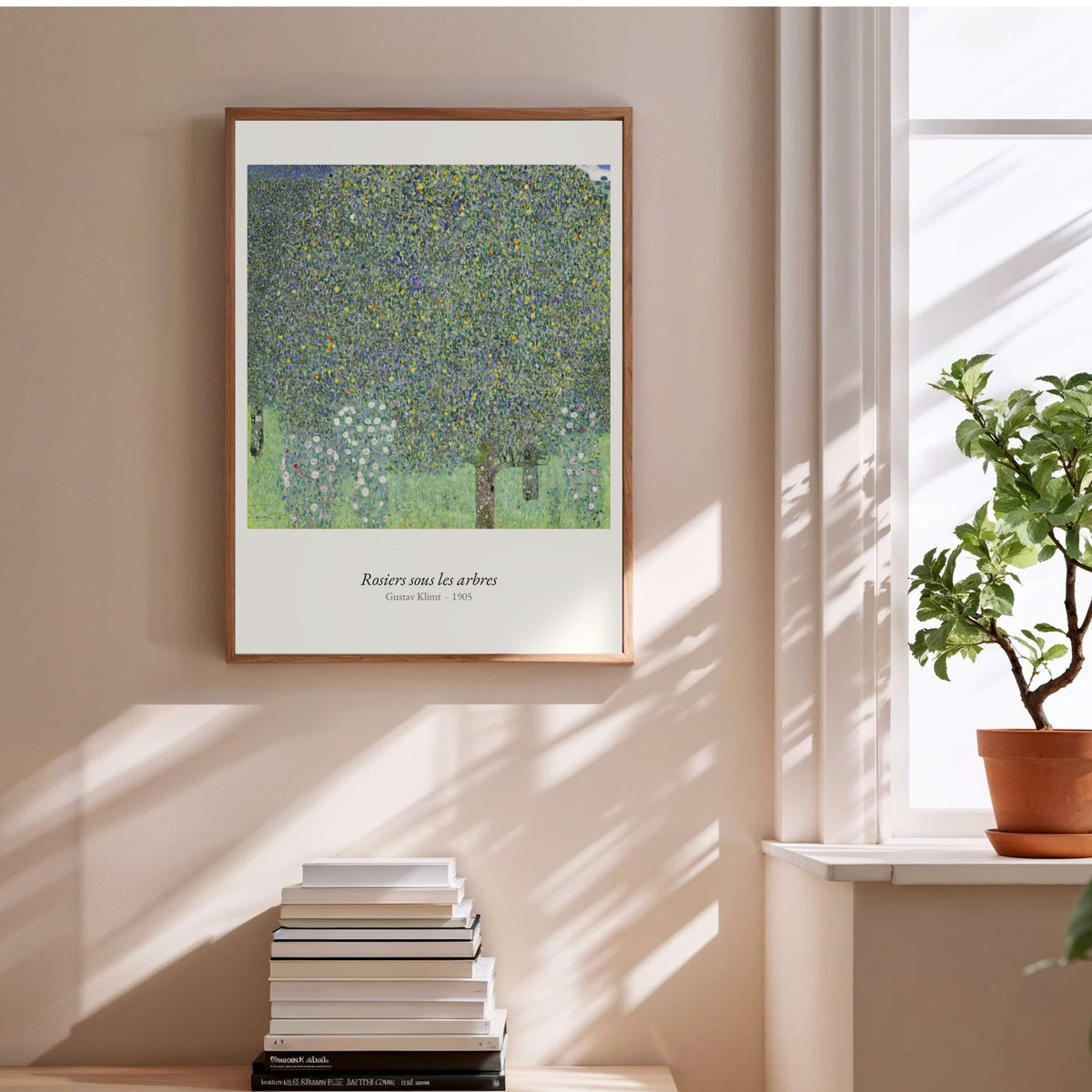 Rosiers sous les arbres, Gustav Klimt, affiche encadrée au-dessus d'une pile de livres