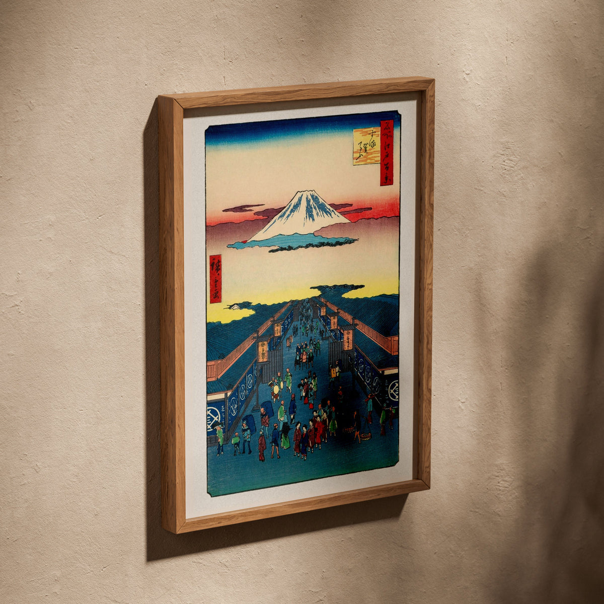 Rue Suruga, Edo - Estampe Japonaise, affiche dans un cadre en chêne posé de biais sur un mur texturé