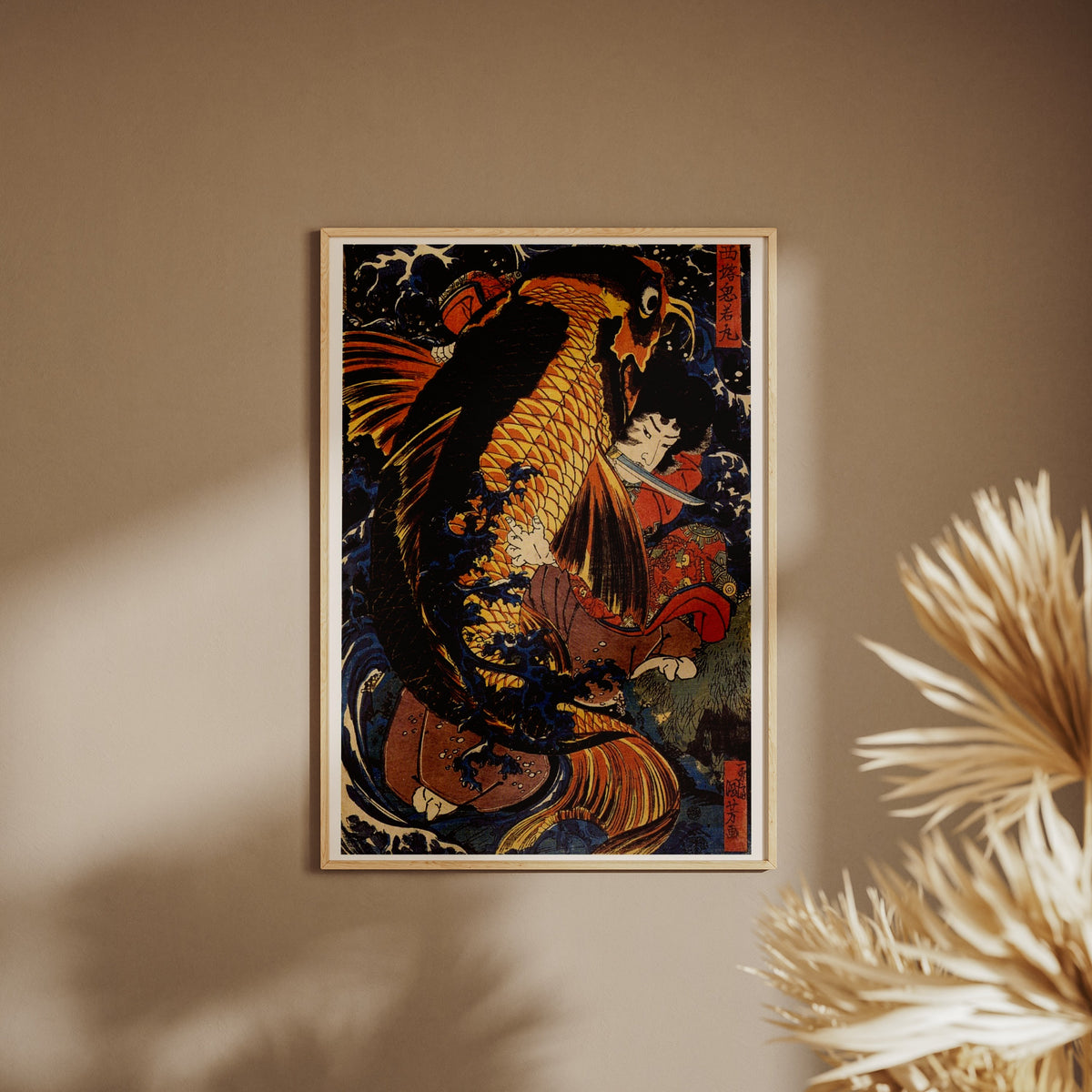 Saitō Oniwakamaru contre la Carpe Géante - Utagawa Kuniyoshi, affiche encadrée sur un mur beige, pampas au premier plan