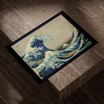 Hokusai Great Wave fine art print lying on a concrete block in evening light