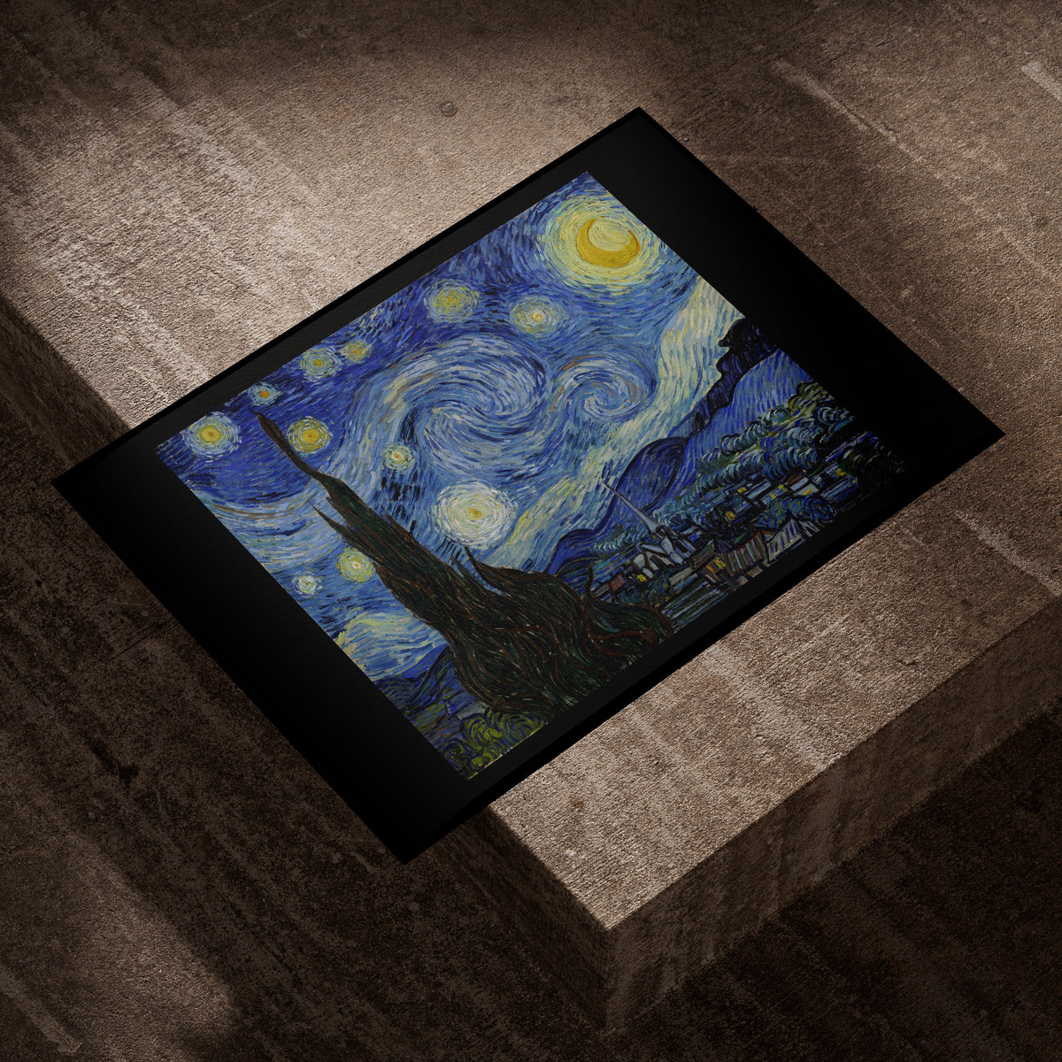 Van Gogh Starry Night fine art print lying on a concrete block in evening light