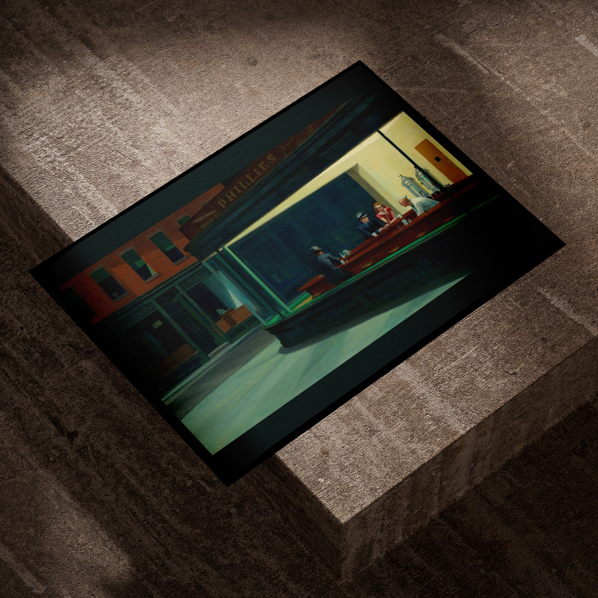 Edward Hopper Nighthawks fine art print lying on a concrete block in evening light