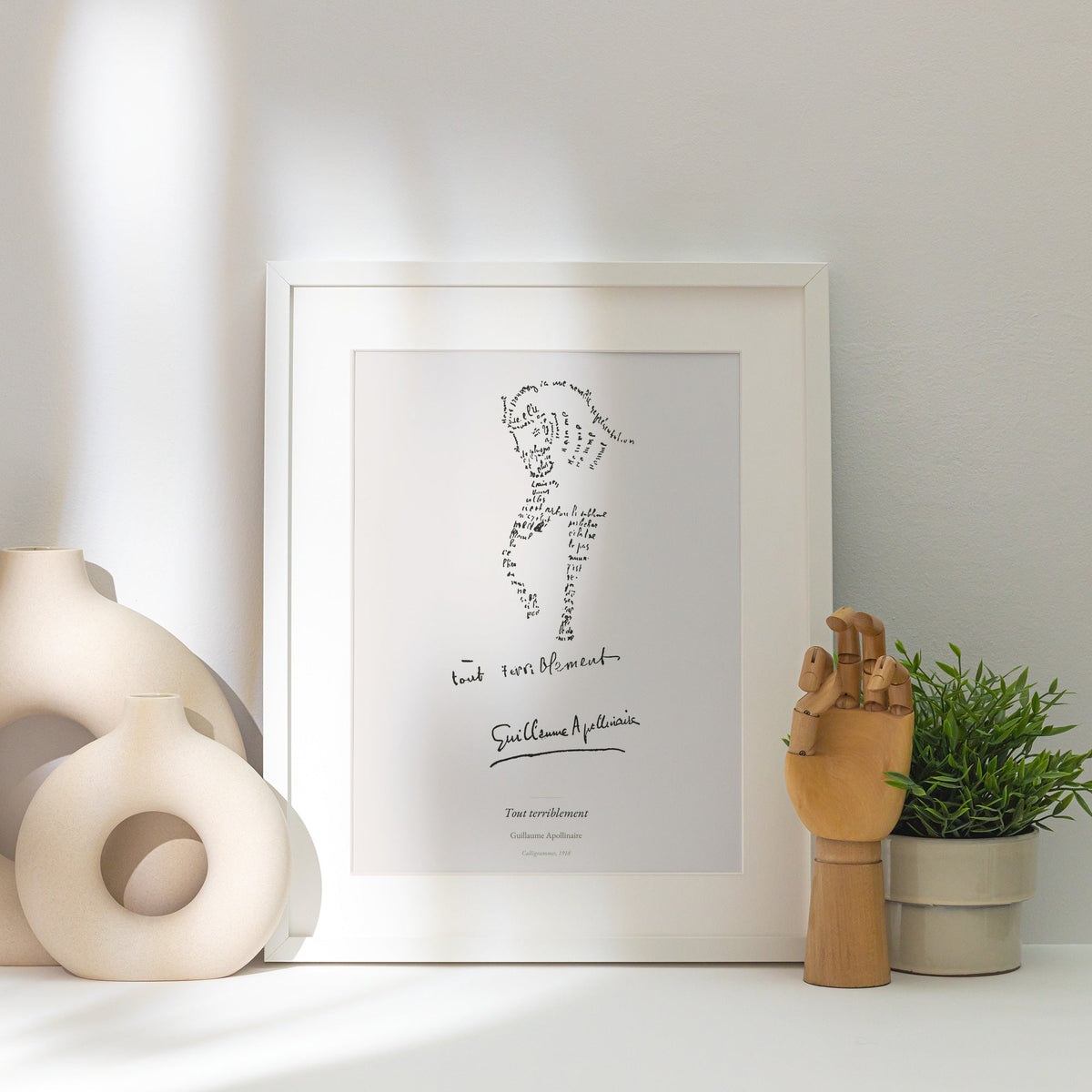Tout terriblement - Apollinaire - Affiche Calligramme Poésie, affiche encadrée posée près d'un vase blanc, lumière rasante