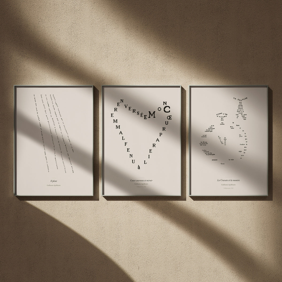 Triptyque Apollinaire en 50x70 : Il pleut, Cœur couronne et miroir et La Cravate et la montre, encadrés côte à côte sur un mur beige