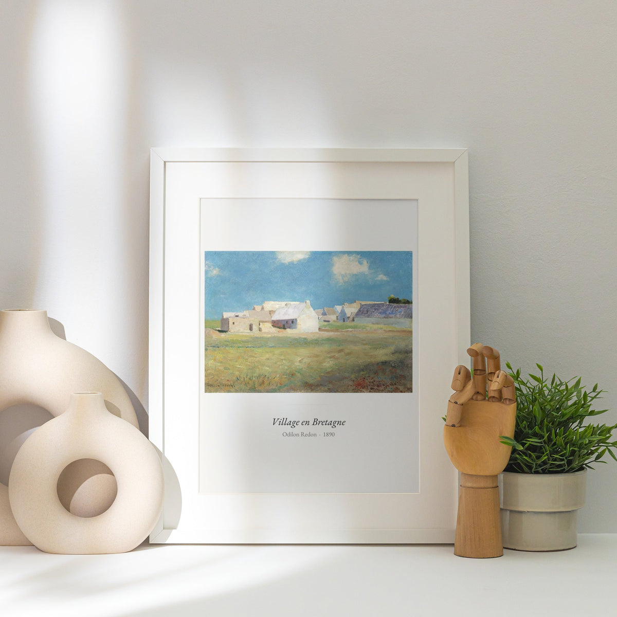 Village en Bretagne, Odilon Redon | Affiche Art Premium, affiche encadrée posée près d'un vase blanc, lumière rasante