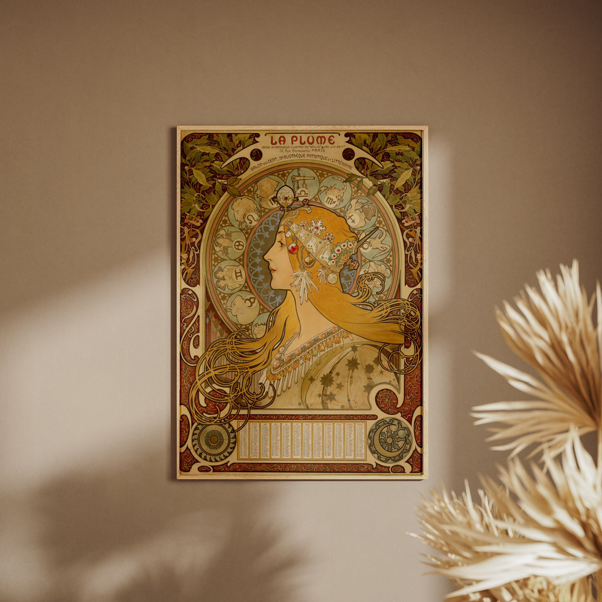 Zodiaque La Plume - Alphonse Mucha, affiche encadrée sur un mur beige, pampas au premier plan